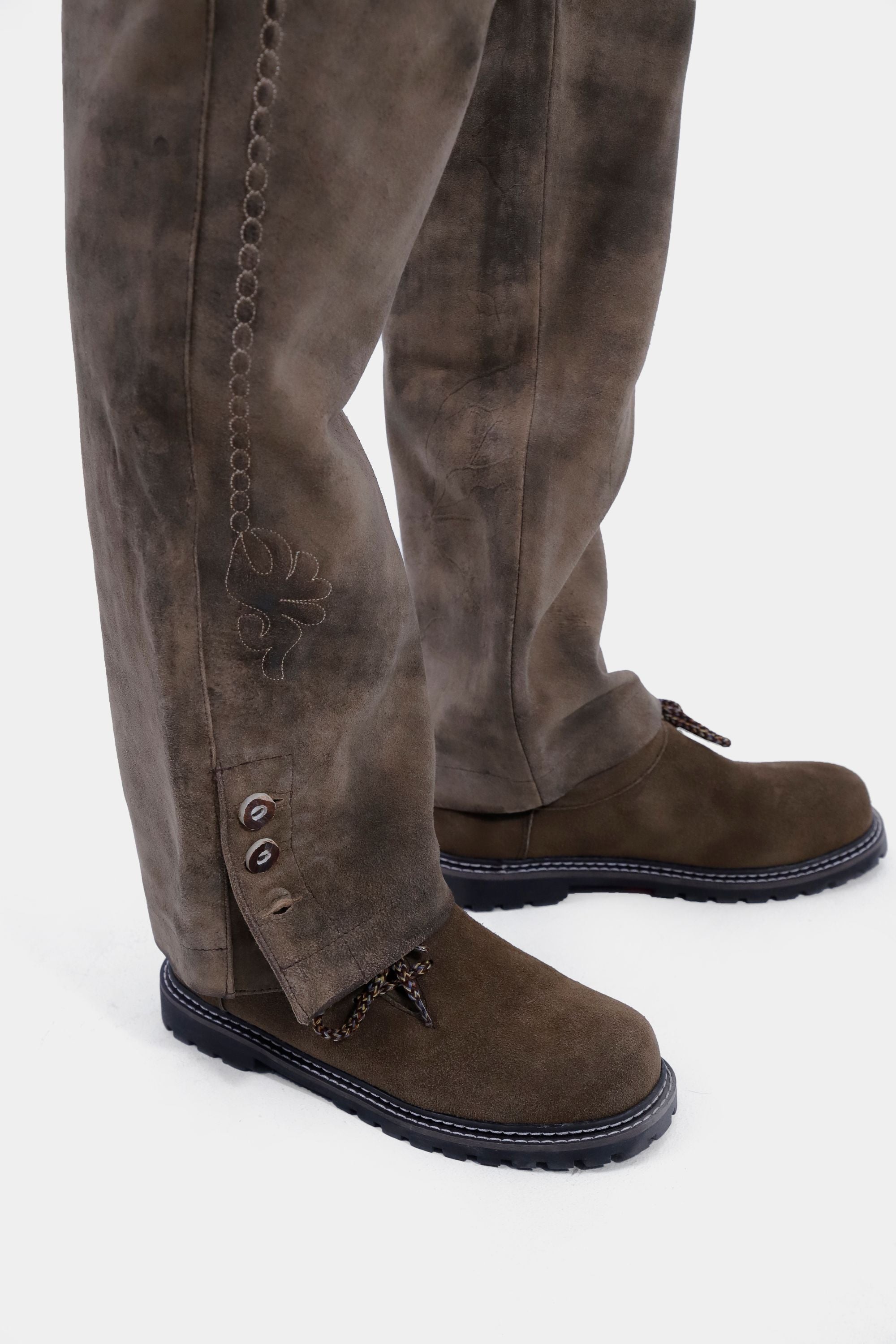 Closed side view from bottom of a man wearing lederhosen long paired with brown matching shoes