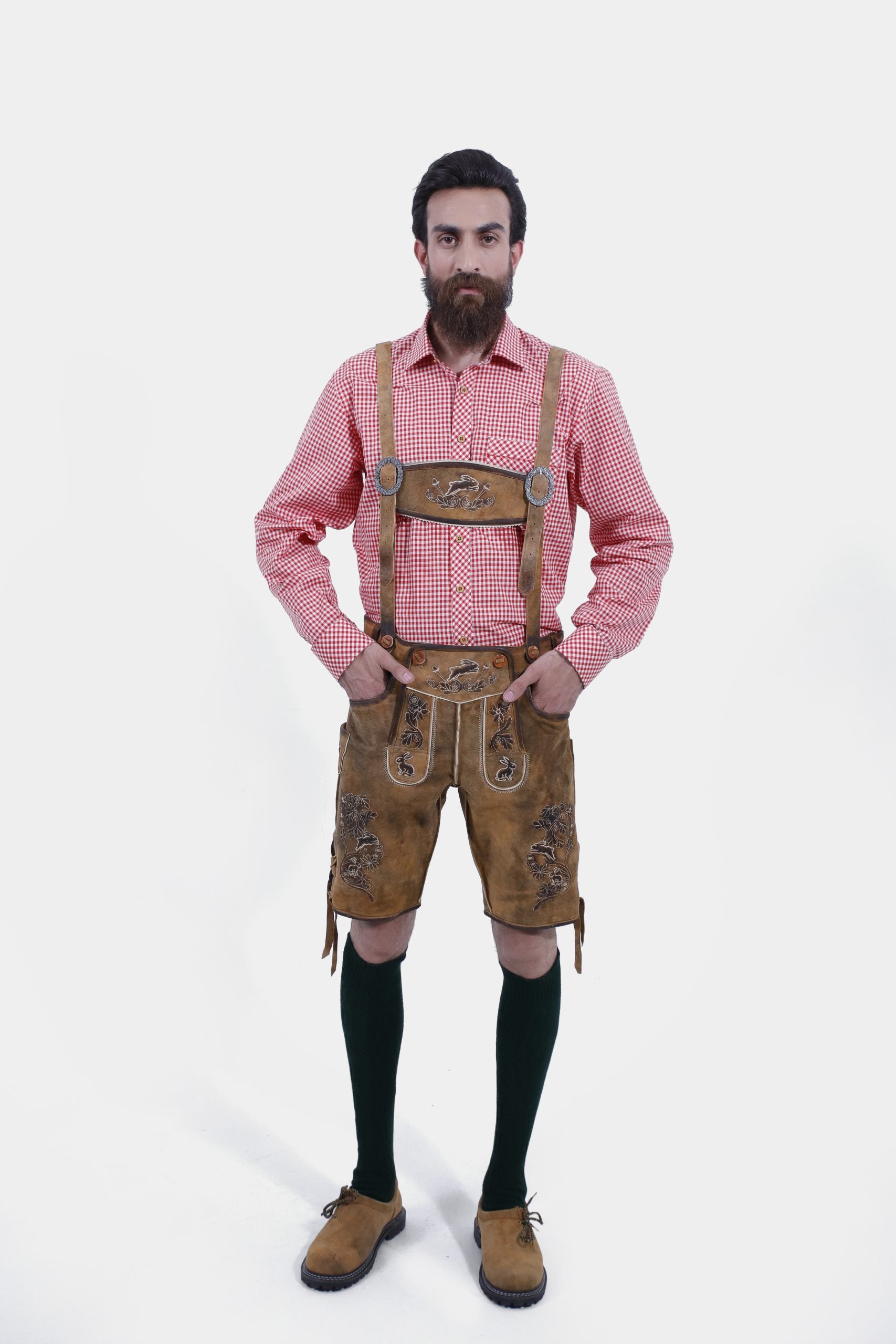 A man wearing Oktoberfest Tulsa Lederhosen suspenders featuring decorative buckles and embroidered leather, paired with a red and white checked shirt.