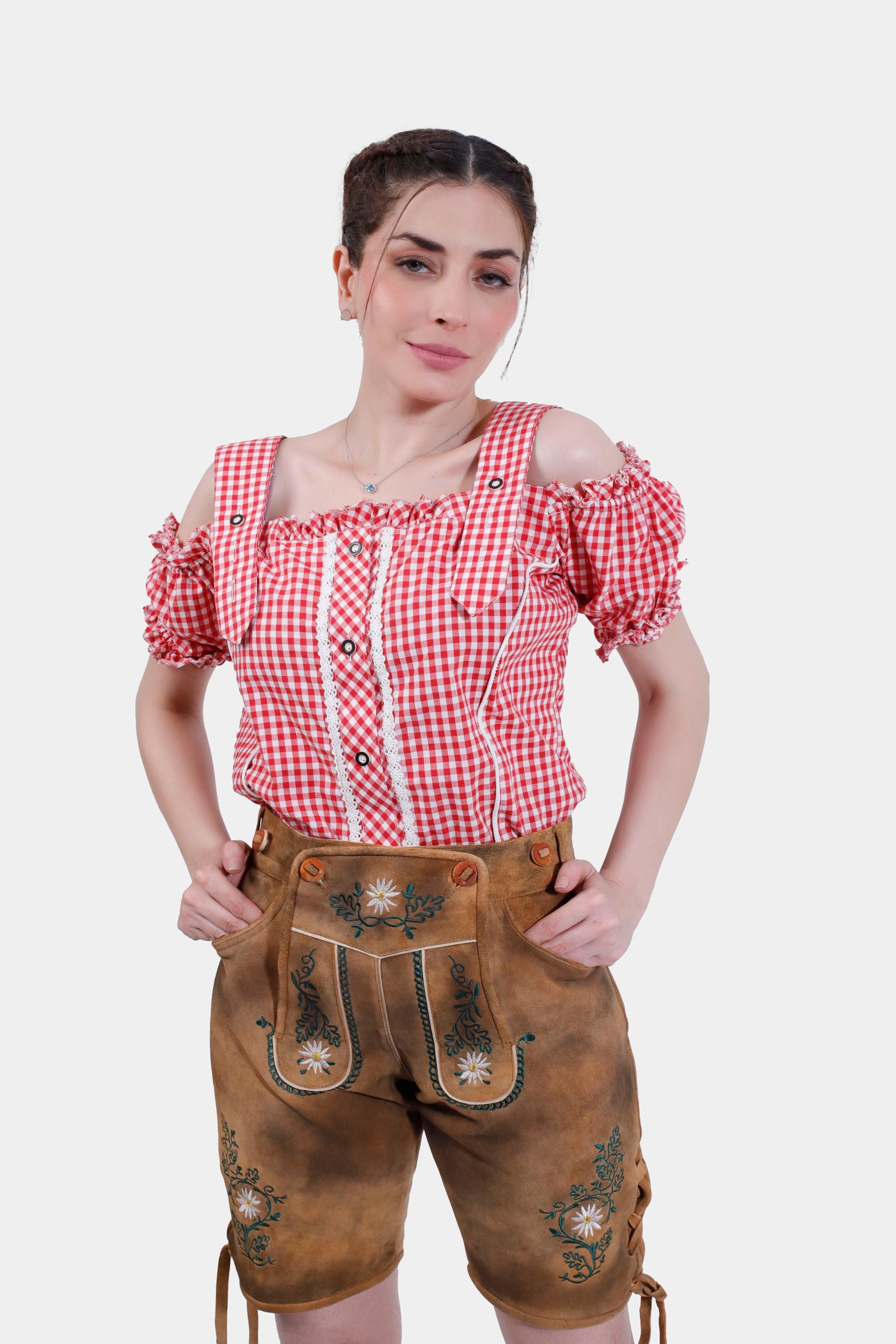 Woman wearing Olivia Rodrigo Lederhosen in Forest Honey color, paired with a red checkered top, posing confidently with hands in pockets.