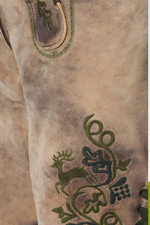 Close-up of detailed deer and vine embroidery on mens lederhosen, showcasing fine craftsmanship and traditional design elements.