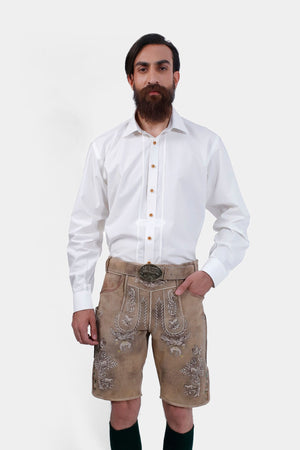 Man dressed in Schweinsteiger Lederhosen, featuring beige leather shorts with intricate white embroidery, a white button-up shirt, and dark green knee-high socks, embodying traditional Bavarian style.
