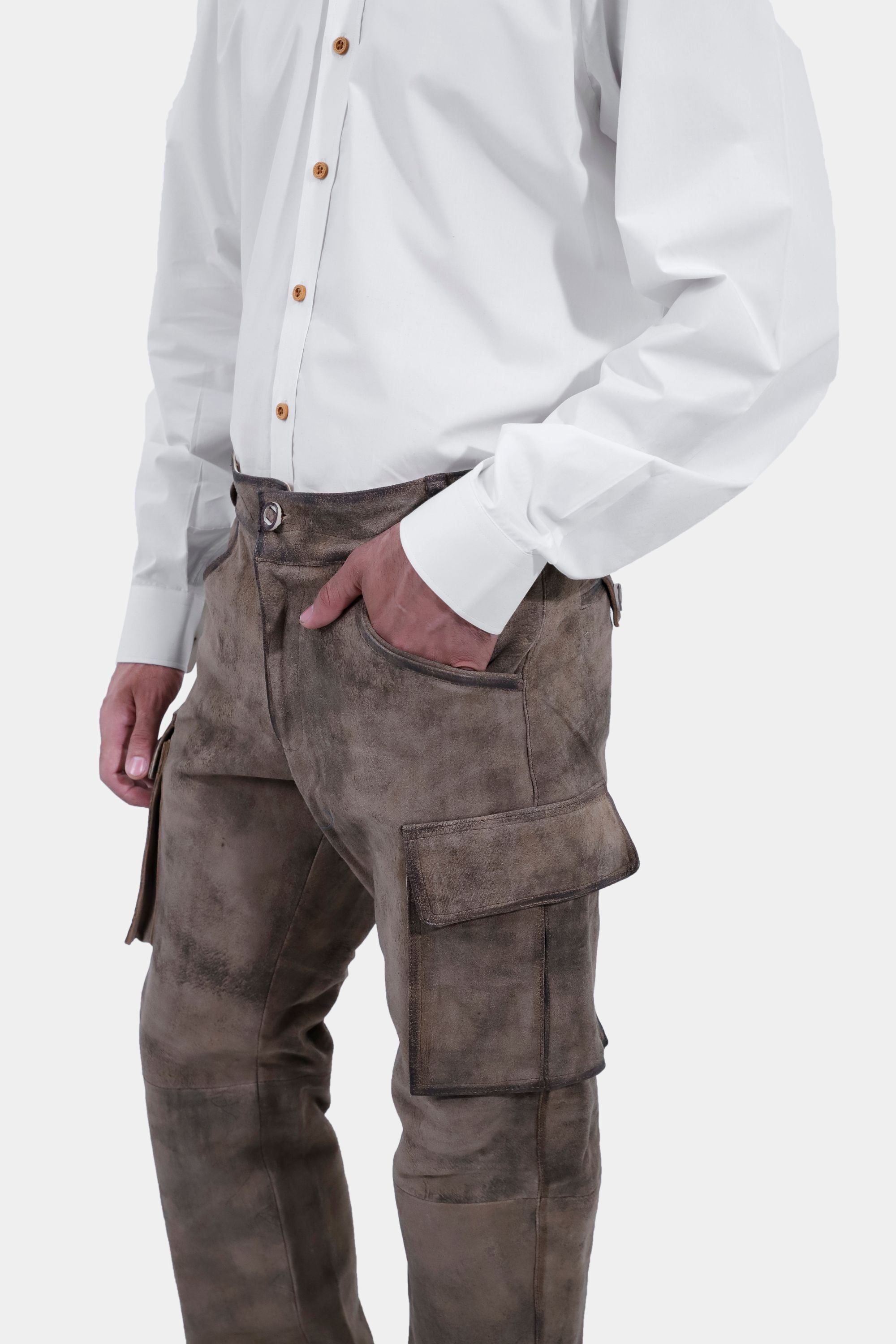 closed side view of a man wearing stamberg cargo long lederhosen paired with plain white shirt