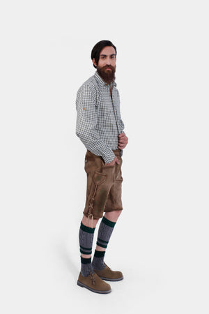 Man wearing Thuringian Forest Dragons Lederhosen with a checkered shirt and knee-high socks, posing from the side