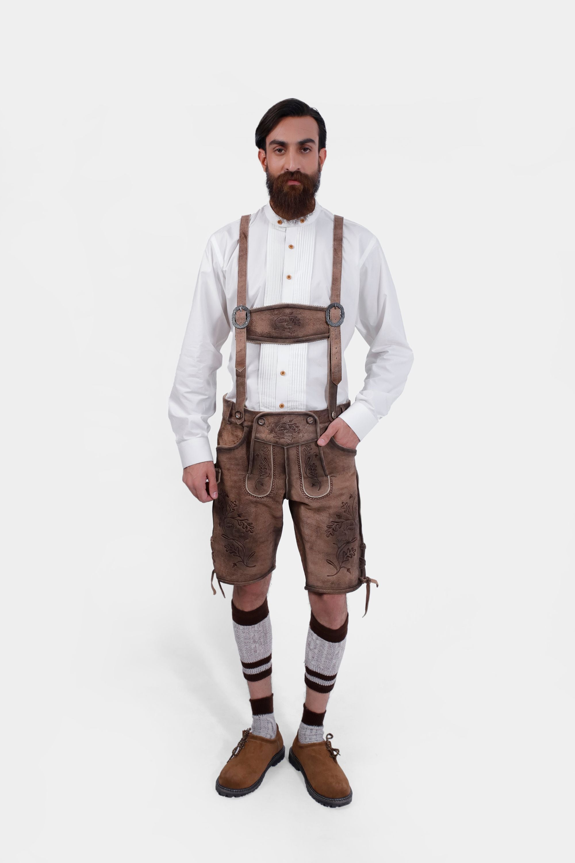 Complete front view of a man wearing Timber Trail Lederhosen in Caramel Earth with suspenders in natural embroidery, goat suede leather, and multiple pockets.