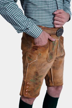 A side view of the man, showing the detailed side buttons and embroidery on the lederhosen. His hand is in his pocket, giving a casual yet poised look.