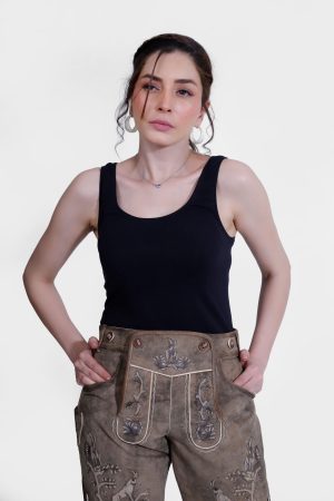 Woman wearing Alpine Regal Lederhosen in Desert Oak, goatskin leather, with embroidery and horn buttons.