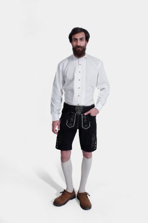 Man wearing Black Edelweiss Lederhosen in Obsidian Twilight with natural embroidery, white shirt, and traditional knee-high socks.