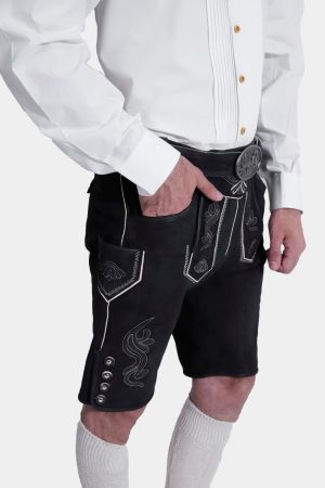 Closed side view of a man wearing Black Edelweiss Lederhosen in Obsidian Twilight with natural embroidery, white shirt