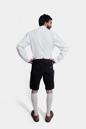 Back view of a man wearing Black Edelweiss Lederhosen in Obsidian Twilight with natural embroidery, white shirt, and traditional knee-high socks.