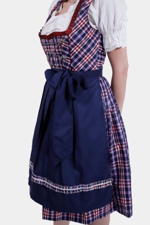 Side view of the woman in the Dirndl dress, highlighting the navy blue apron and the full skirt with a plaid underlay. The white blouse sleeves are puffed, adding to the traditional Bavarian look.