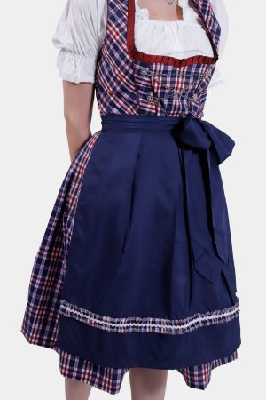 Close-up of the navy blue apron tied into a large bow, showing the plaid underlay and the intricate detailing of the Dirndl dress fabric.