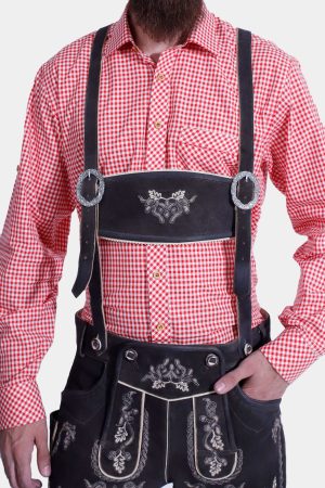 Closed view of a man wearing black Lahm Lederhosen with detailed white embroidery, paired with a red checkered shirt, and traditional suspenders.