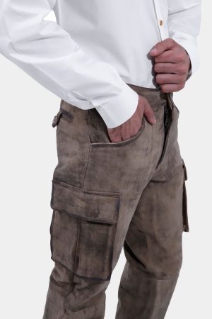 closed side view of a man wearing stamberg cargo long lederhosen paired with plain white shirt